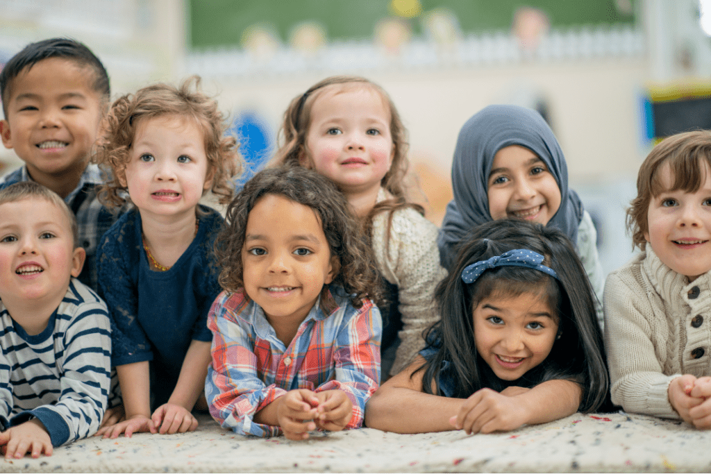 diverse group of young children pose smiling on floor